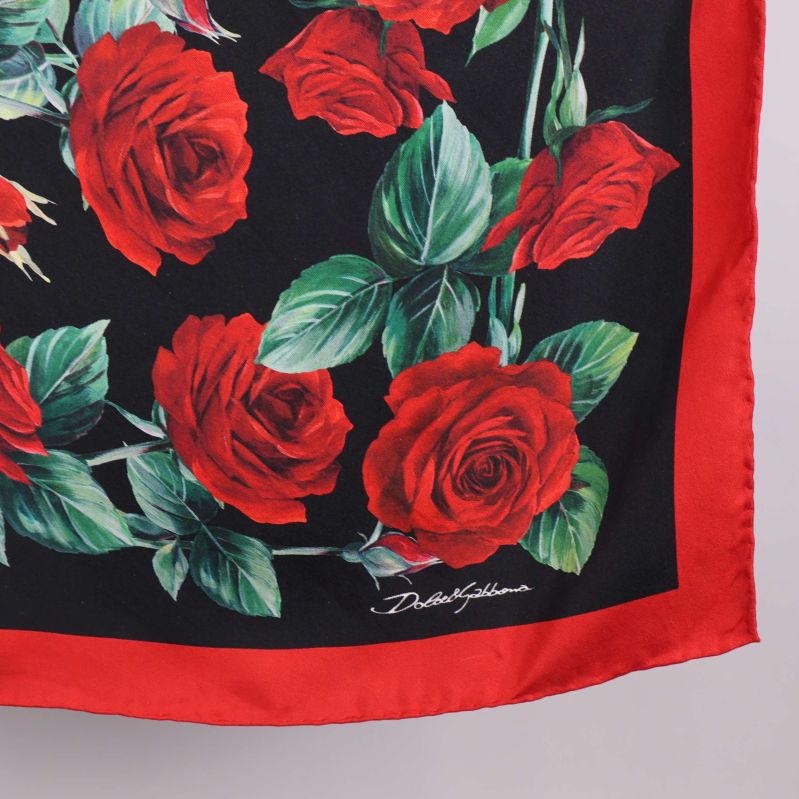 Närbild på hörn av scarf och rosor samt signatur