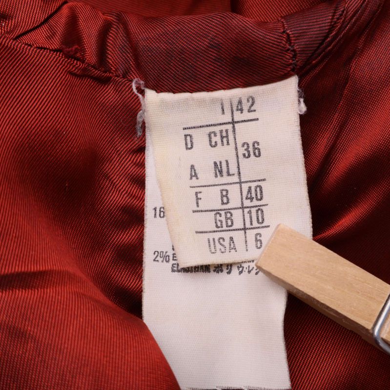 Storleksetikett med EU 40 och andra storlekar för röd kavaj