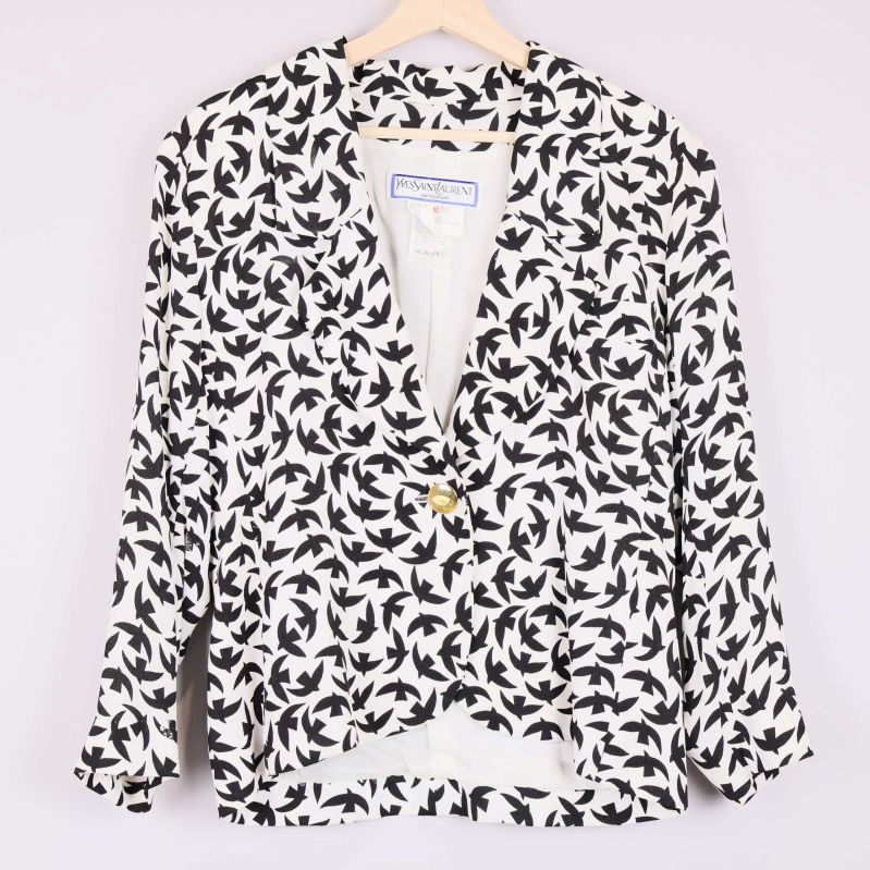 Framsida av svartvit kavaj med fågelmönster och guldknapp