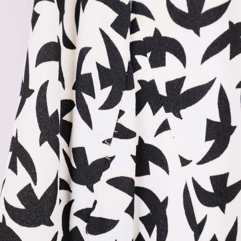 Närbild av tyg med svart på vitt fågelmönster