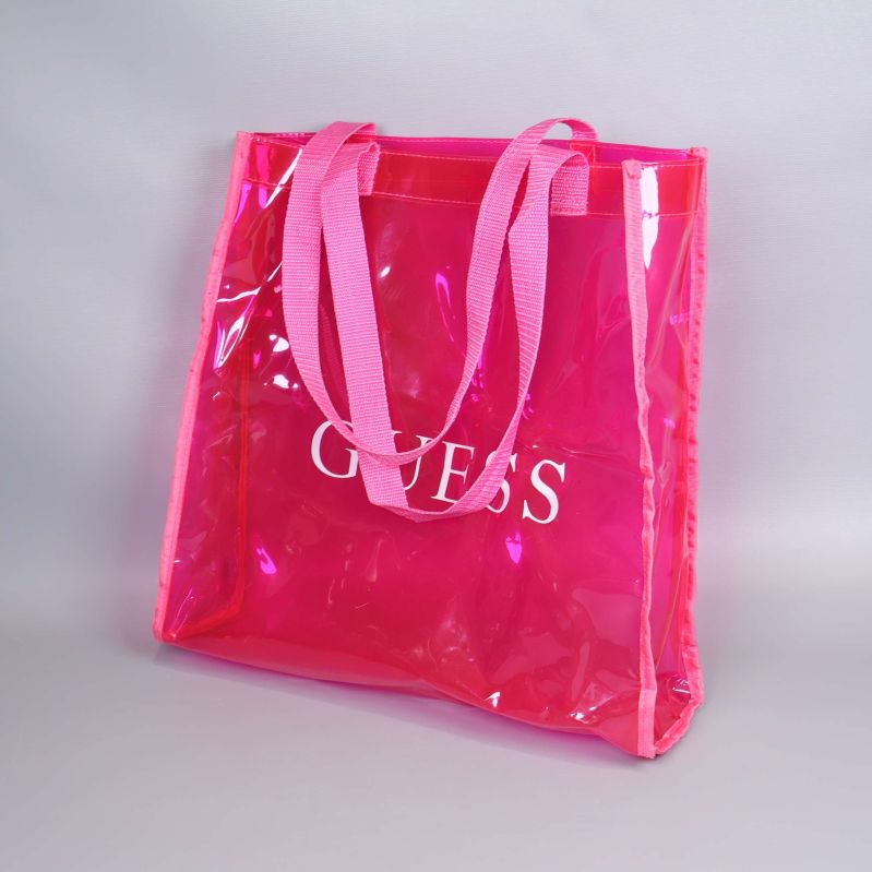 Framifrån av transparent rosa Guess-väska med handtag