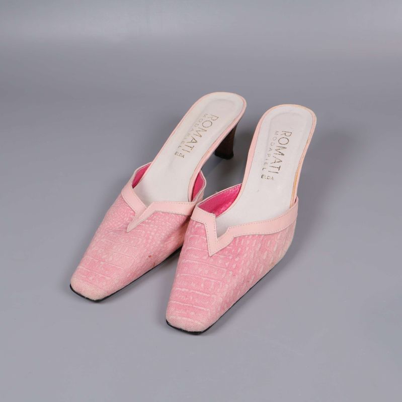 Rosa mules med klack i frontvy på grå bakgrund