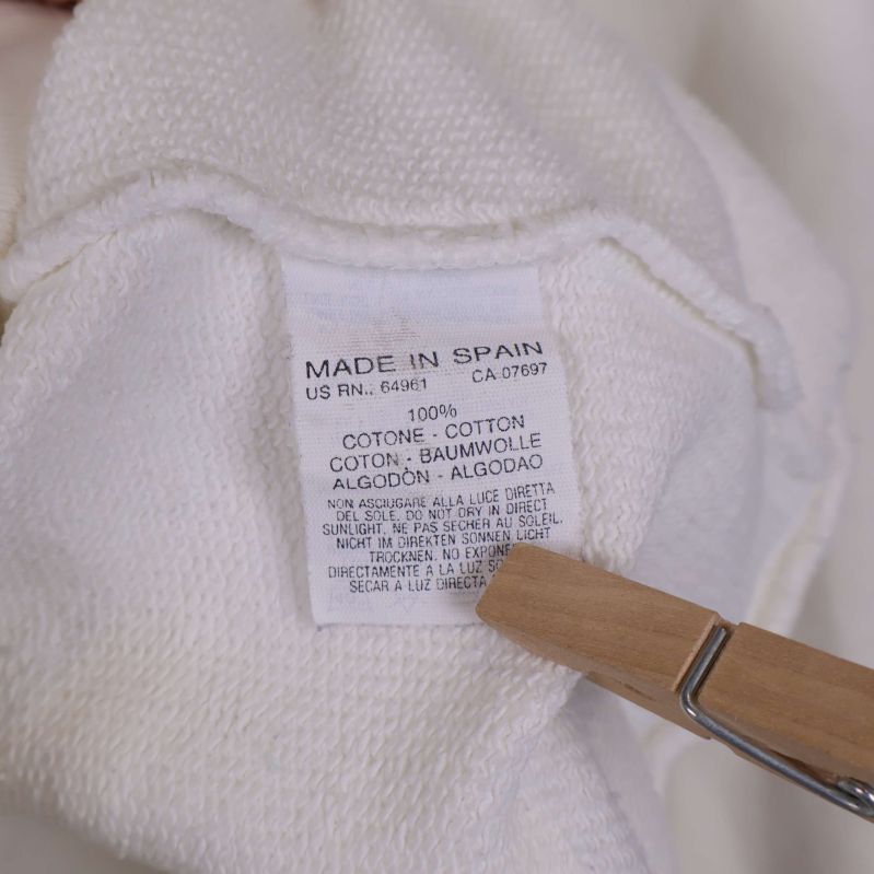 Materialetikett som visar 100% bomull, made in Spain