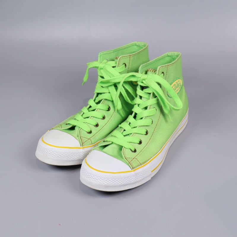 Ett par höga limegröna sneakers med gula sömmar och vit tådel