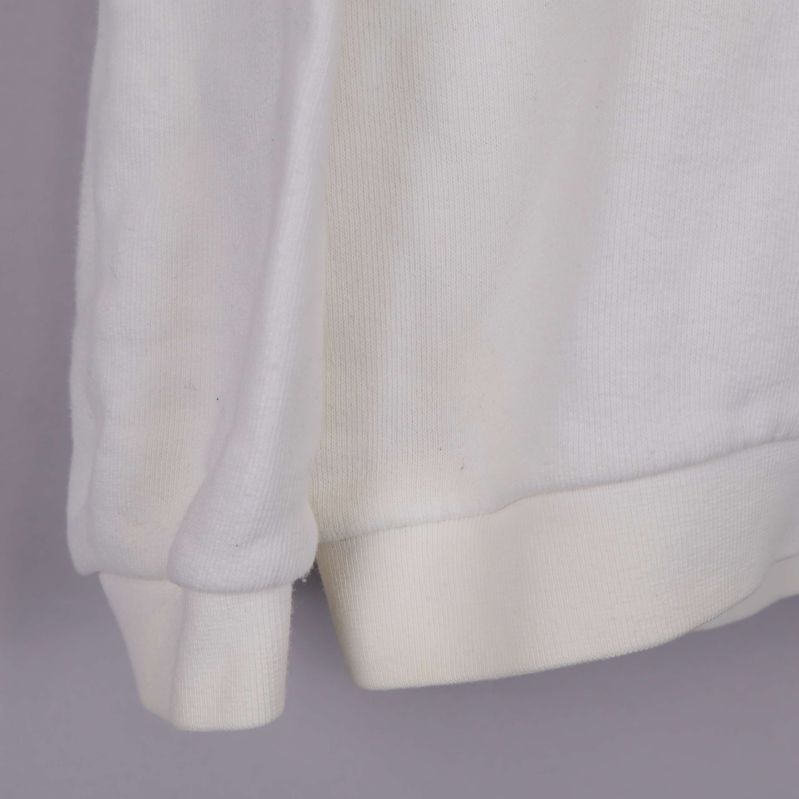 Närbild på avslut och muddar på vit sweatshirt