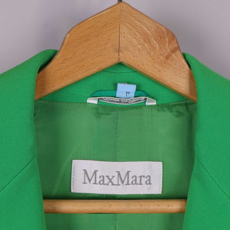 Närbild på MaxMara-märket i grön kavaj