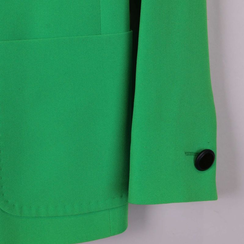 Närbild på kavajärm med svart knapp