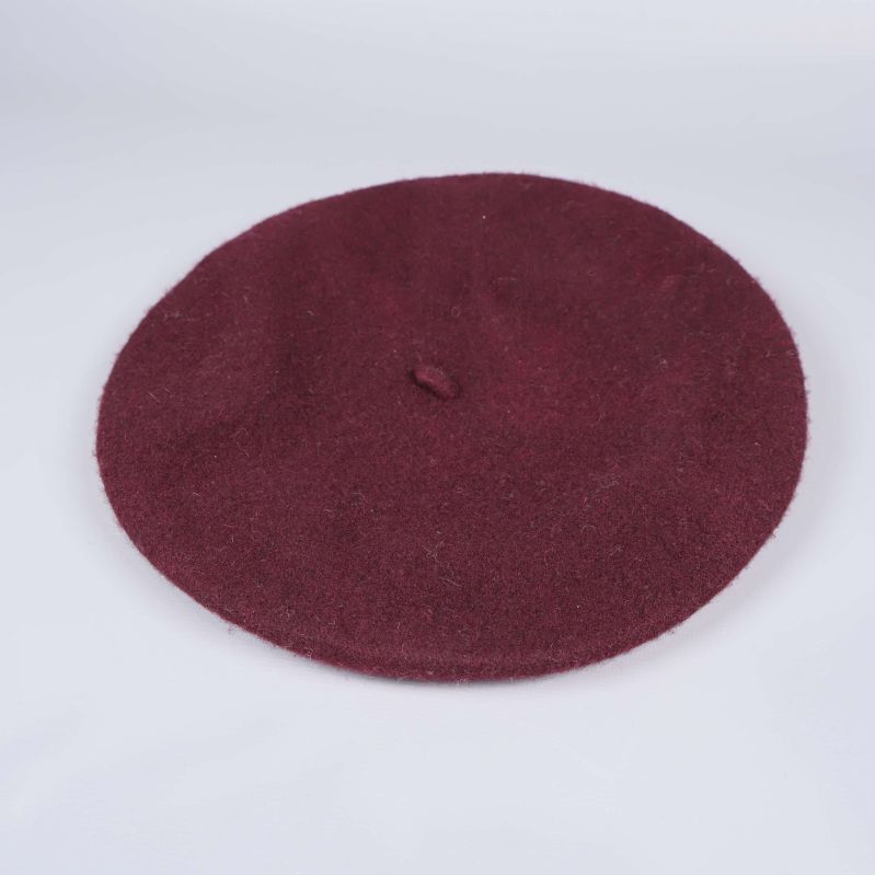 Vinröd basker liggande på vit bakgrund