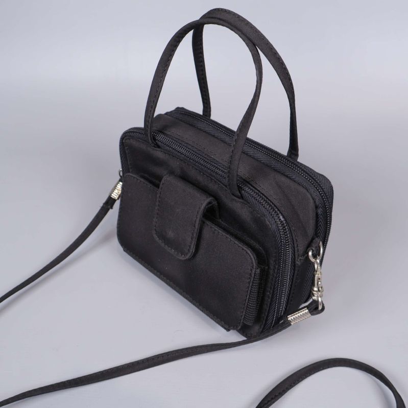 Närbild på svart väska med framficka och dubbla handtag