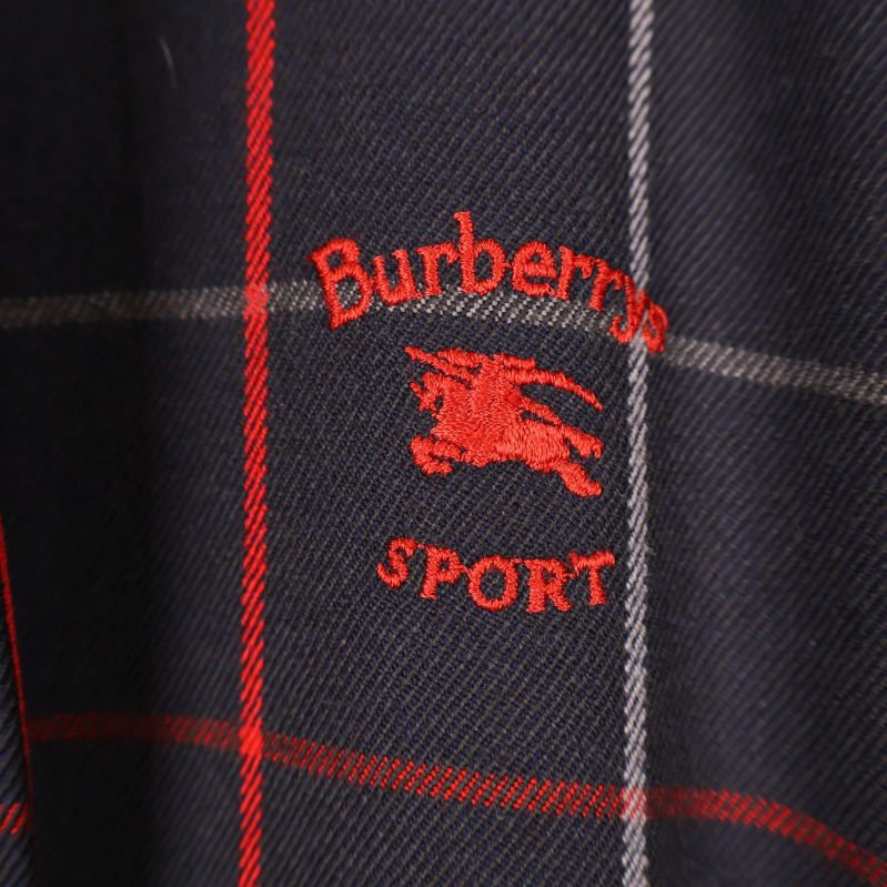 Broderad Burberrys SPORT-logga i rött på jackan