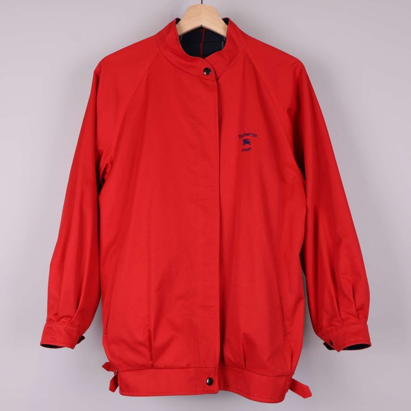 Vändbar jacka med enfärgat röd sida och logga