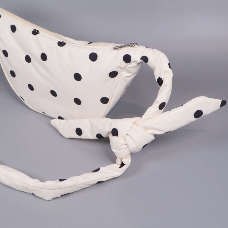 Närbild på knytband på prickig magväska