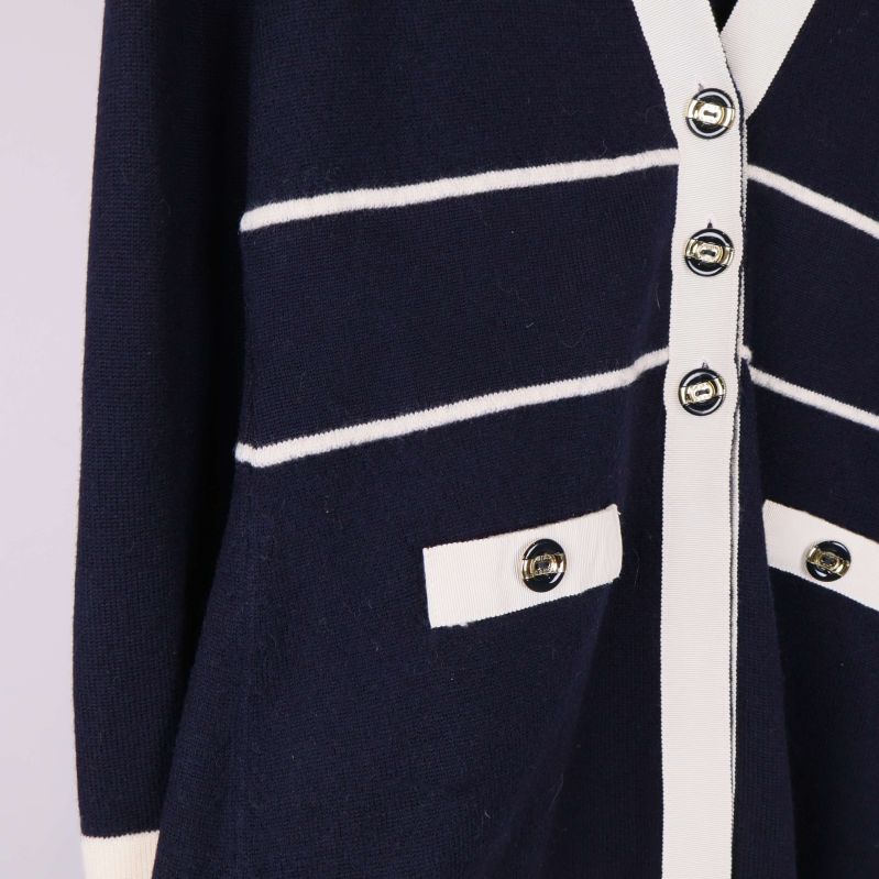 Närbild på fickor och dekorativa knappar på koftan