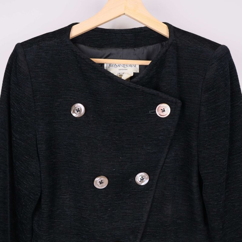 Närbild på knappar och krage framtill på svart kavaj