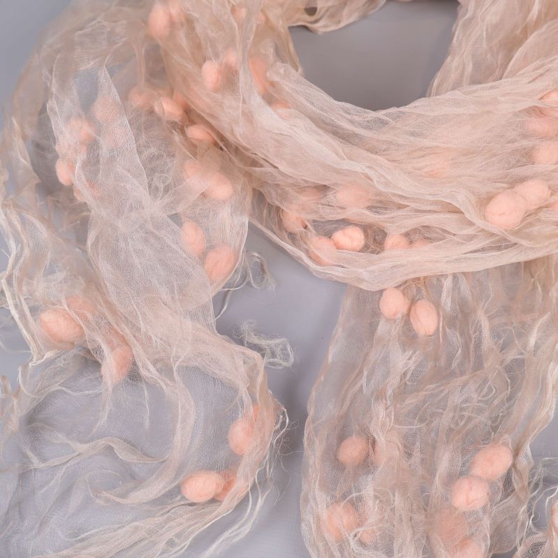 Närbild på sjalens struktur och flera ljusa pompoms