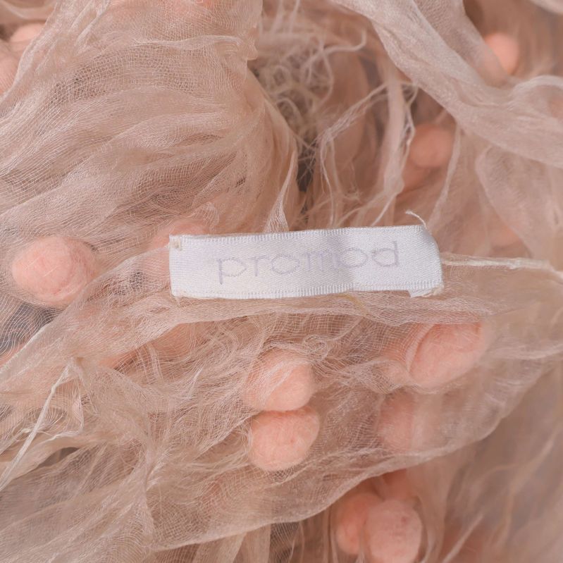 Närbild på etikett där det står promod fäst vid sjalens kant