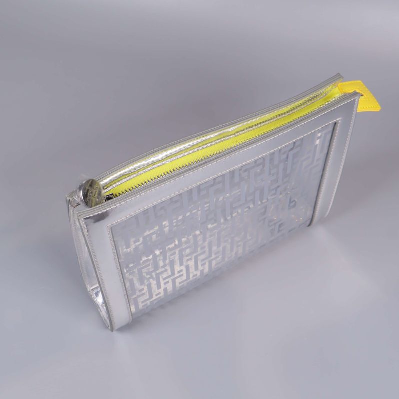 Necessär i transparent material med gul dragkedja sedd ovanifrån