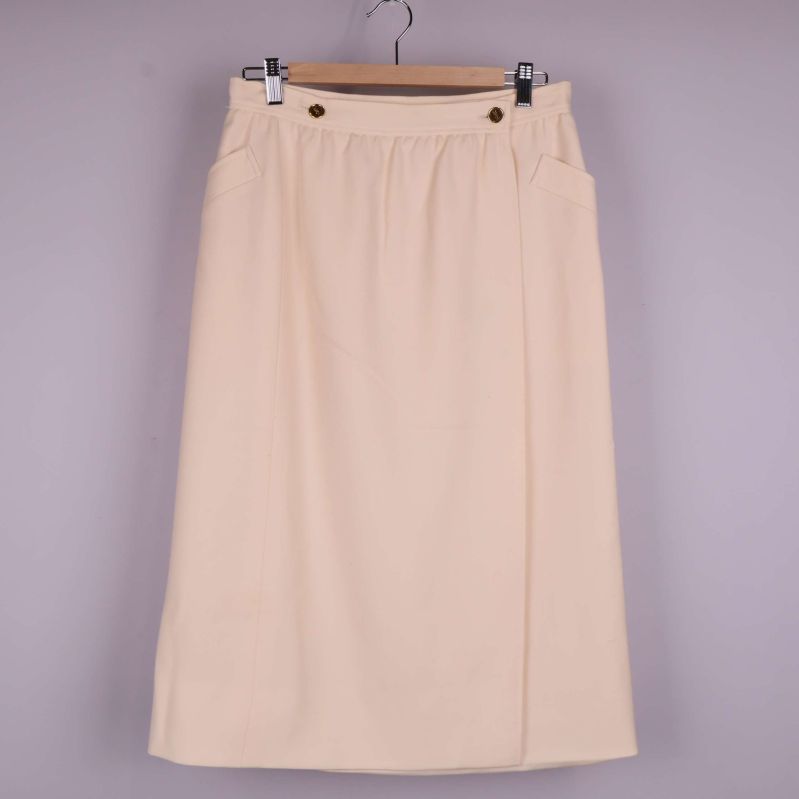 Helbild av beige kjol framifrån med raka linjer och guldknappar