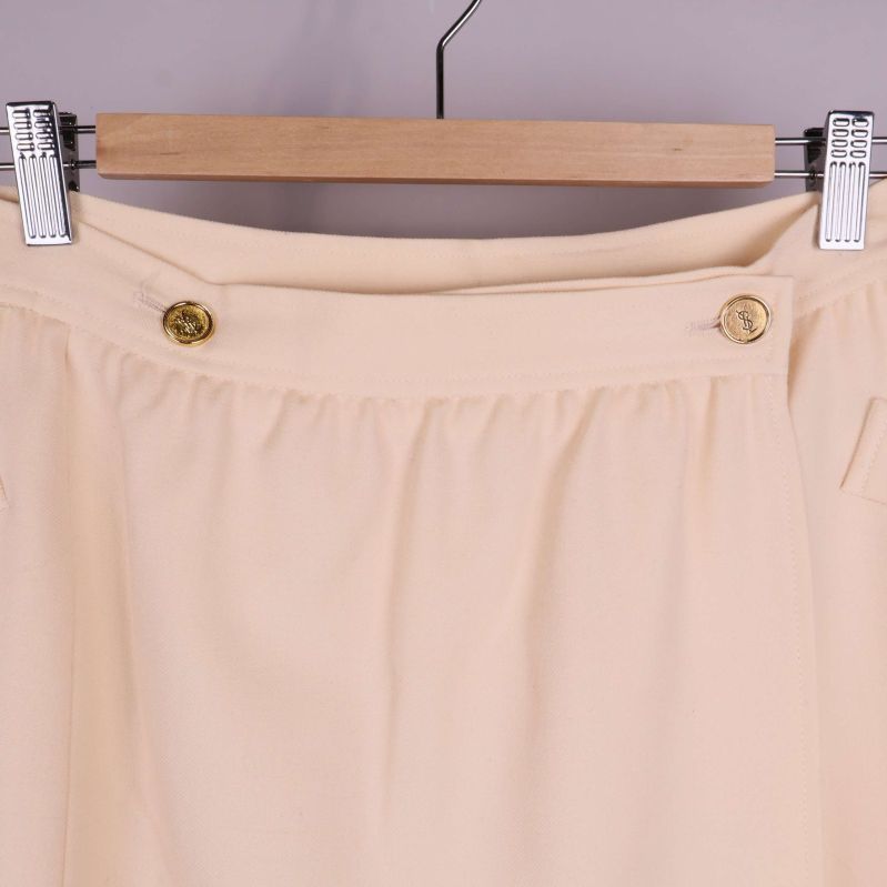 Närbild på midjan med två guldfärgade knappar och veck