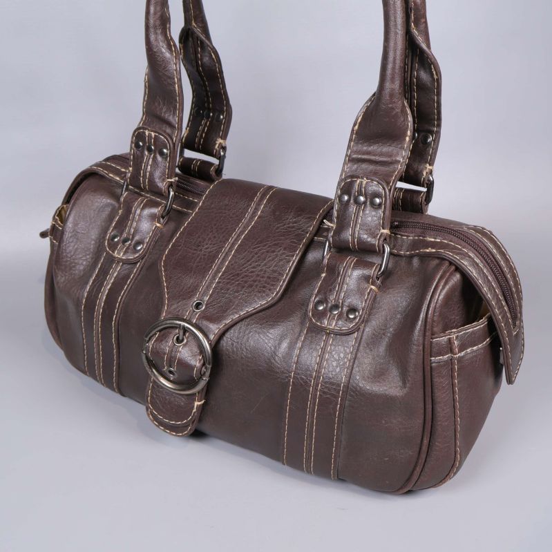 Närbild på axelväska och dess detaljerade metallspänne