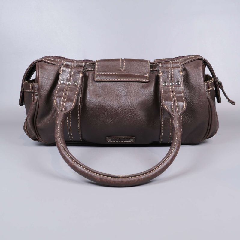 Baksida av brun axelväska med dubbelhandtag
