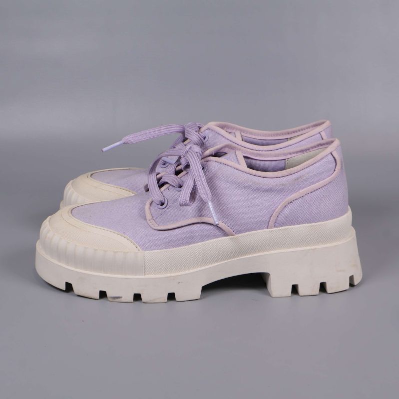 Sneakers sedda från sidan med lila ovandel och vit sula