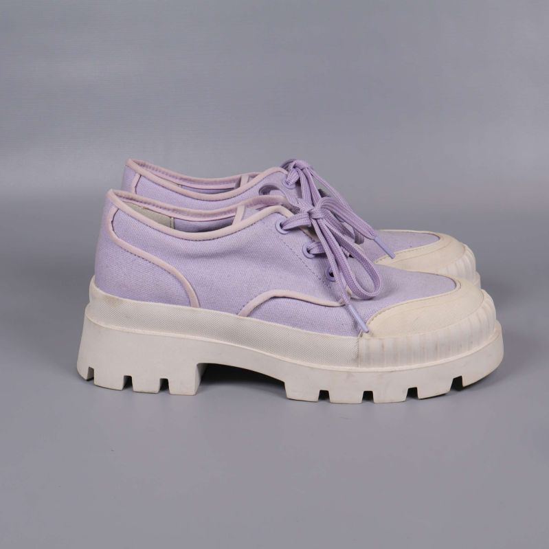 Sneakers sedda från andra sidan, visar sula och materialsammansättning