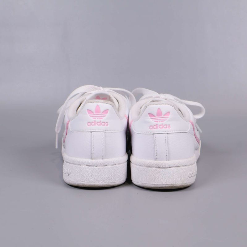 Baksida av vita sneakers med rosa adidas-logga