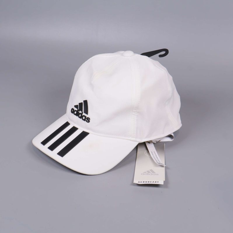 Vit adidaskeps med svarta detaljer och etikett synlig