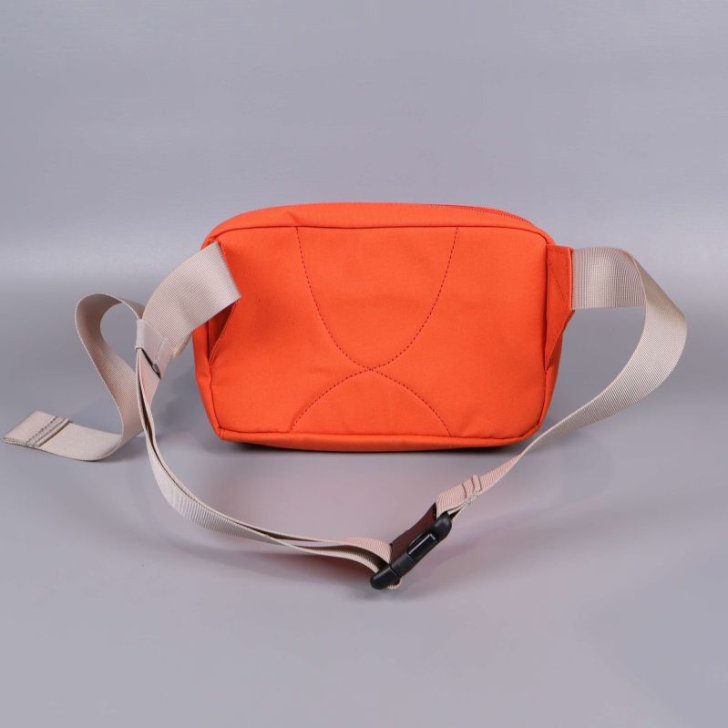 Baksidan av orange axelväska med beige axelrem