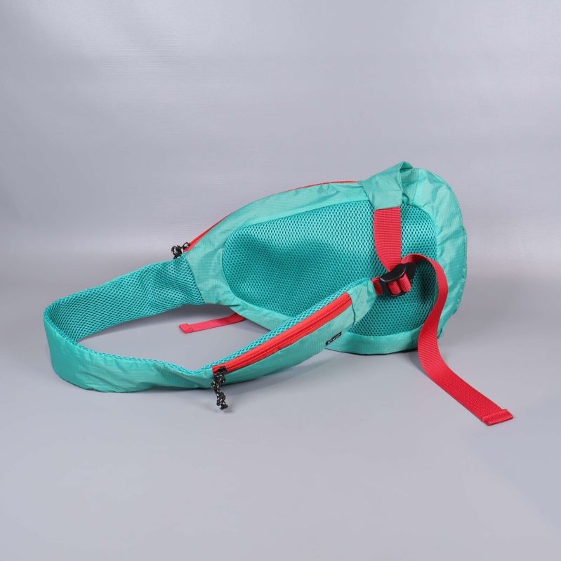 Turkos axelväska liggande med röda remmar och blixtlås