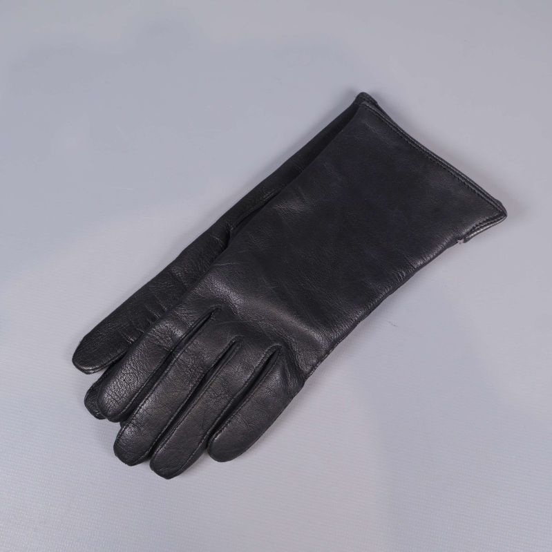 Svarta lammskinnshandskar liggande på grå bakgrund