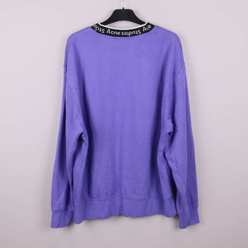 Baksidan av lila sweatshirt visas upphängd