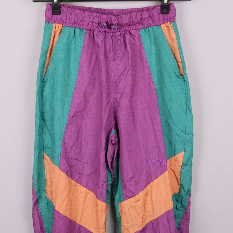 Detaljbild på byxornas midja och fickor med dragkedja