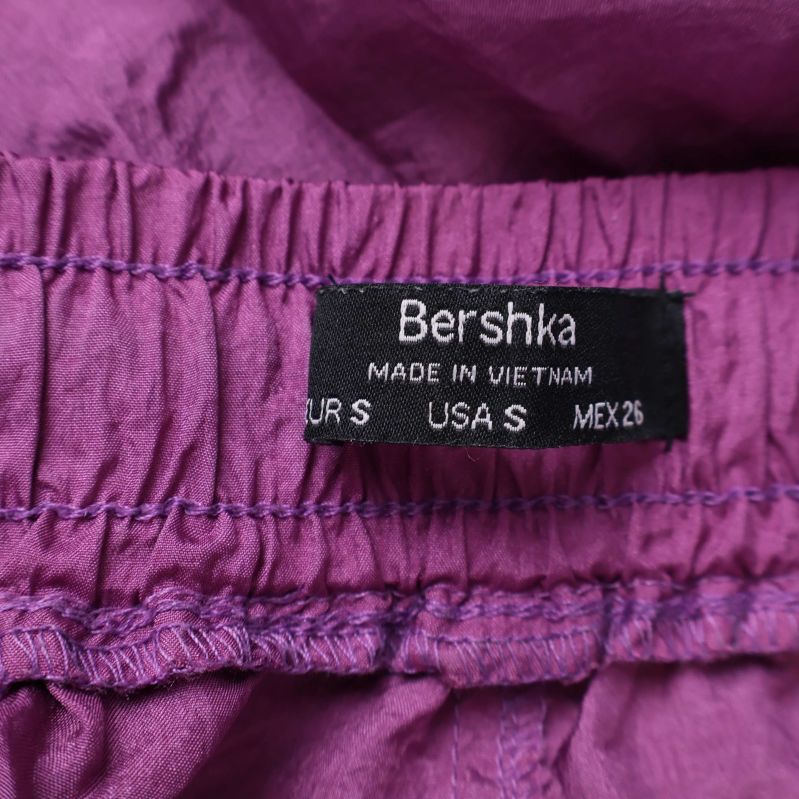 Närbild på Bershka-märkesetikett och storlek i midjan
