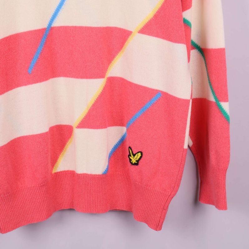 Nedre del av tröja med logotyp broderad vid fållen och färgglada linjer