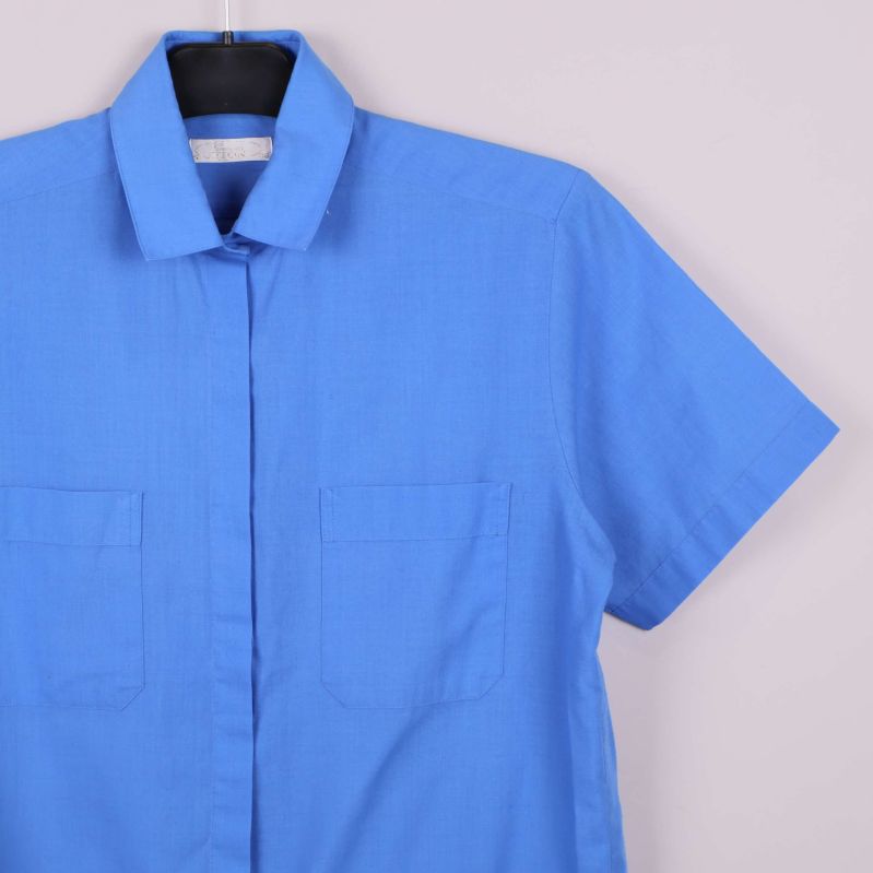 Närbild på blå skjorta med krage och fickor