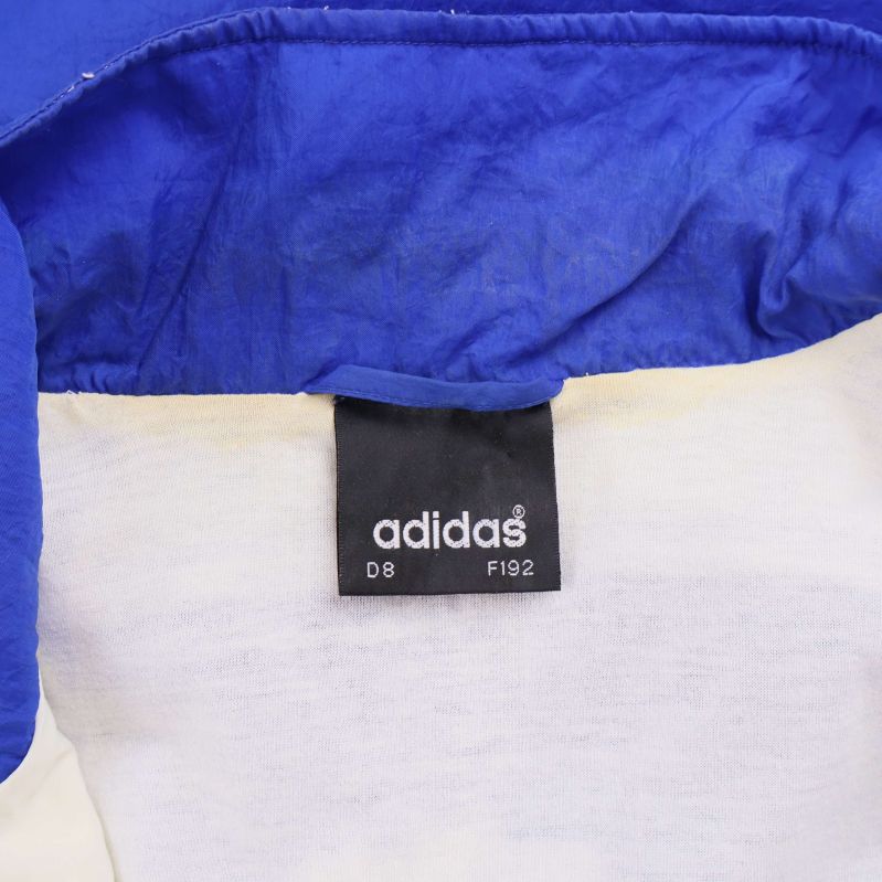 Etikett med Adidas logotyp och storleksangivelser inuti jackan