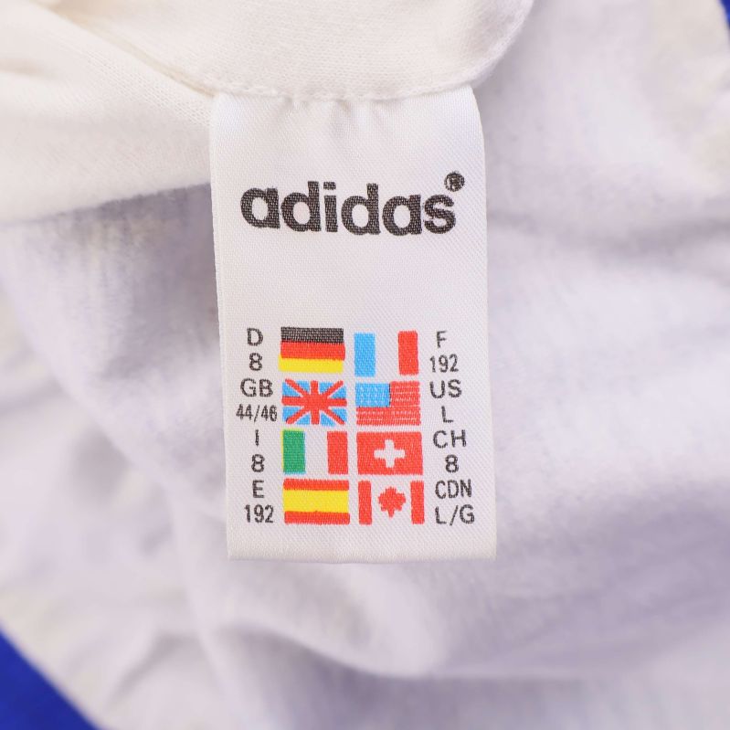 Etikett inuti Adidas jackan med internationella storleksangivelser