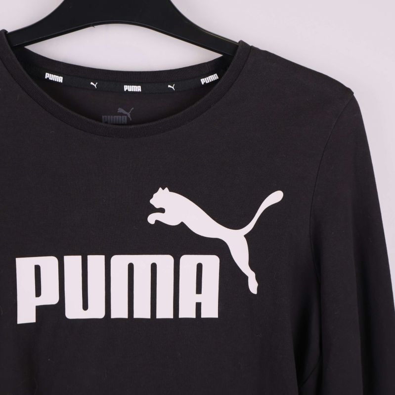 Närbild på vit PUMA-logga framtill på crop top