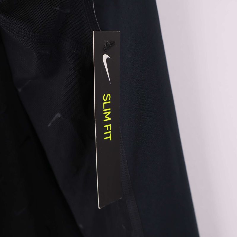 Etikett med texten Slim Fit och Nike-logga på sidan