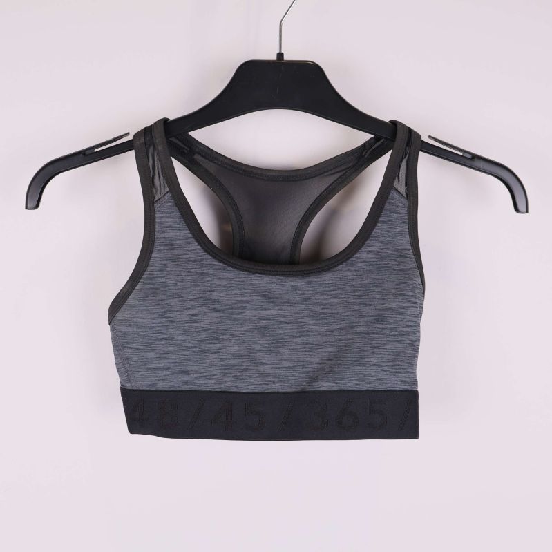 Sport-bh med grå front och svart mesh på galge