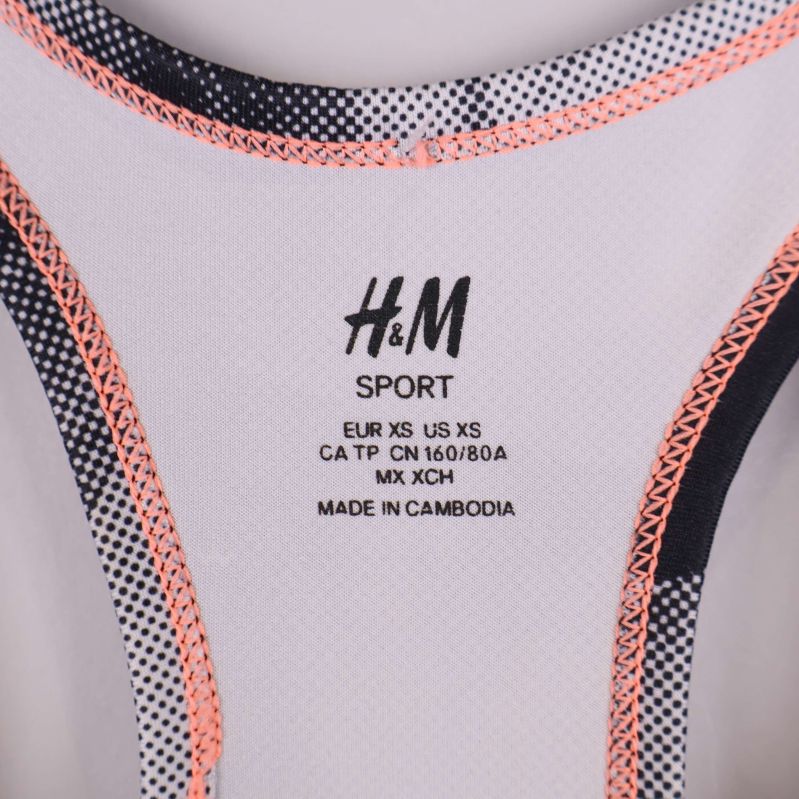 Närbild av H&M Sport-logotyp och storleksinformation i linnet
