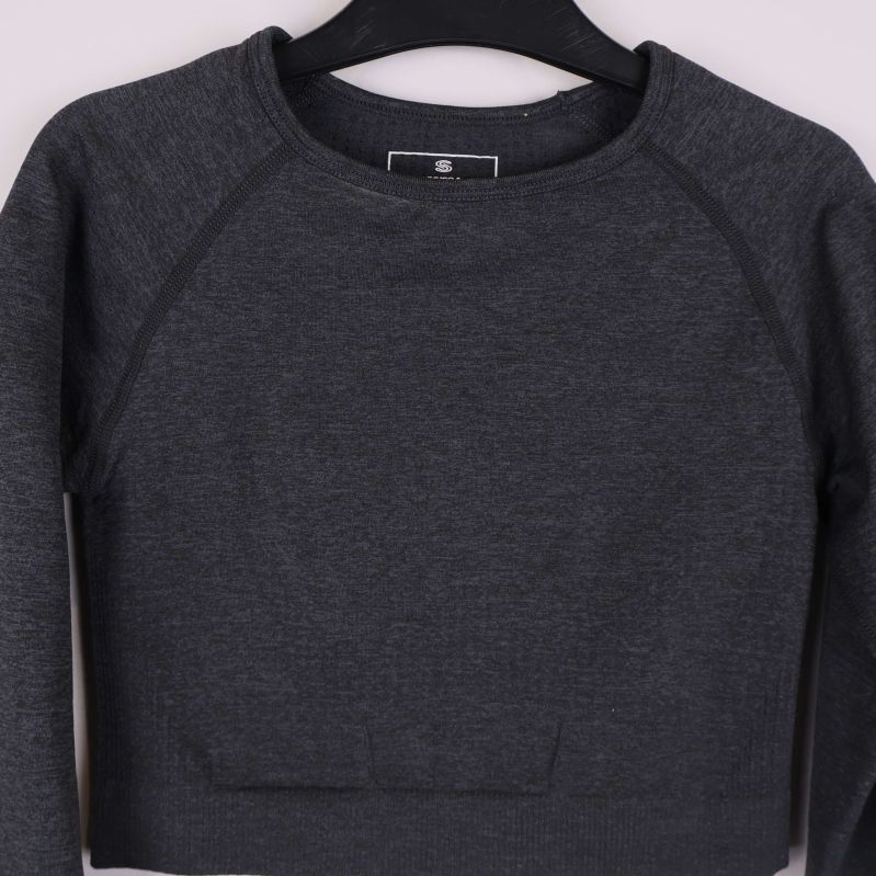 Närbild på cropad tröja med rund hals och sömdetaljer