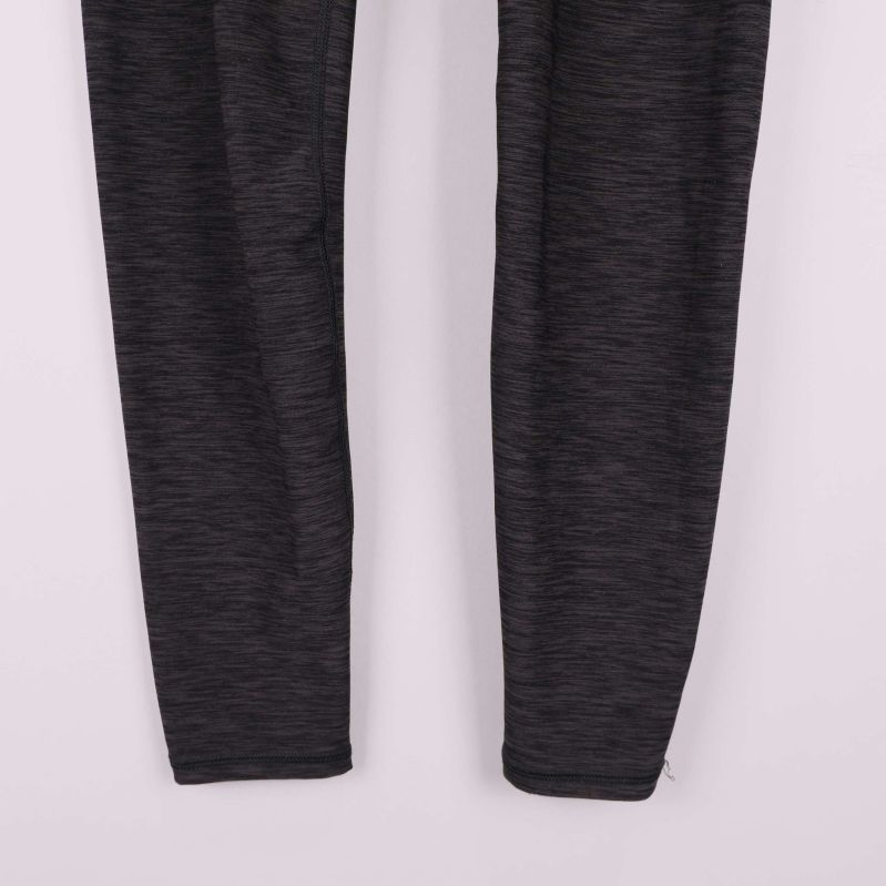 Närbild på leggingsens nedre ben med melerad struktur