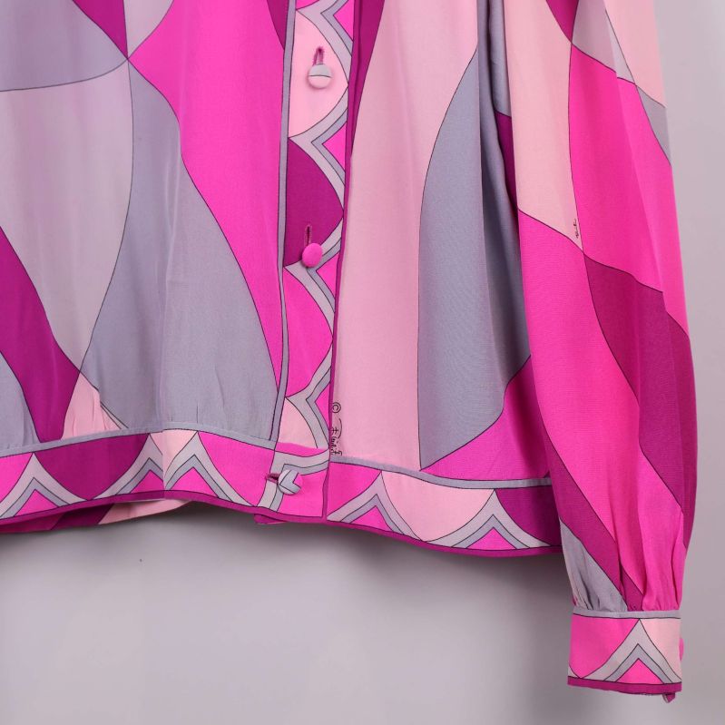 Närbild på knappar och mönstrad nederkant på blusen