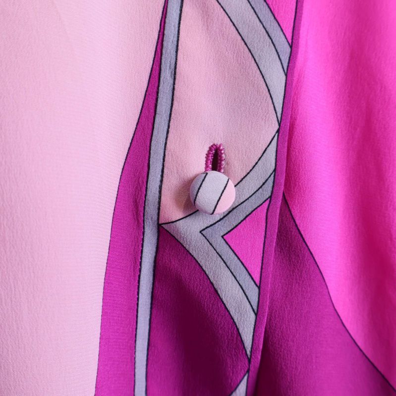 Närbild på knäppning med tygklädd knapp