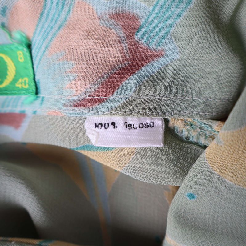 Materialetikett som visar 100% viskos på blusen