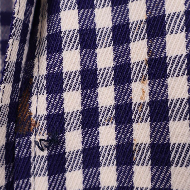 Närbild på materialets rutmönster och fläck
