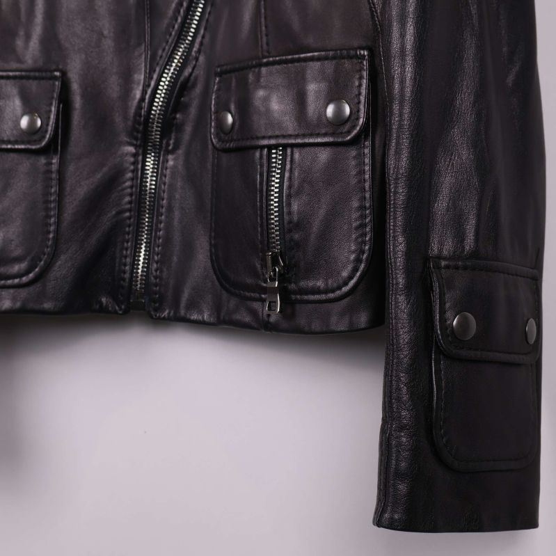 Detaljbild på svart läderjackas fickor och dragkedja